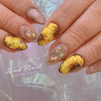 こちらは夏らしいひまわりをモチーフにしたネイルデザインです。鮮やかなイエローのひまわりアートに、繊細なゴールドやシェルが組み合わされ、華やかさと上品さを演出。指先から夏を感じるデザインです。