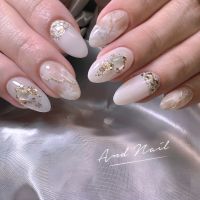 こちらは上品で洗練されたニュアンスネイルデザインです。柔らかなホワイトとゴールドのアートが絶妙に調和し、大人の指先にぴったりの華やかさを演出。どんなシーンにもマッチする万能なデザインです。