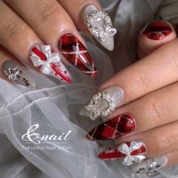 深みのあるレッドを主役にした、大人のためのクリスマスネイル。透明感のある赤に繊細なラメラインを重ねて、上品さと華やかさを両立。立体的なリボンやストーンフレームがアクセントになり、特別な季節にぴったりの存在感に仕上げました。